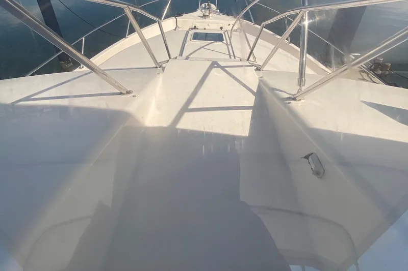 Slide: The Image of 1996 Sea Ray 440 Express Bridge deck with stainless steel railings and clear skies. - 47