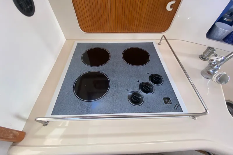 Slide: The Image of Stovetop in 1996 Sea Ray 440 Express Bridge yacht kitchen, featuring three burners and control knobs. - 20