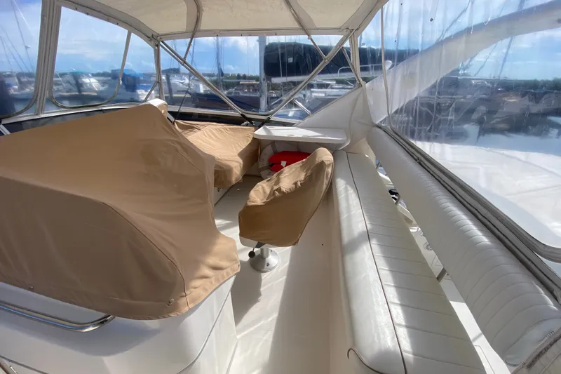 Slide: The Image of 1996 Sea Ray 440 Express Bridge interior with covered seating and clear canopy. - 37