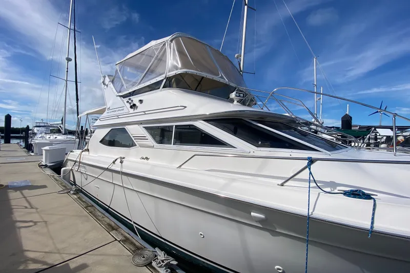 Slide: The Image of 1996 Sea Ray 440 Express Bridge yacht docked under clear blue sky. - 6