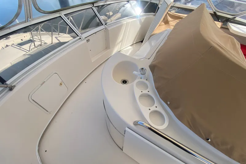 Slide: The Image of 1996 Sea Ray 440 Express Bridge deck with seating and cup holders. - 43