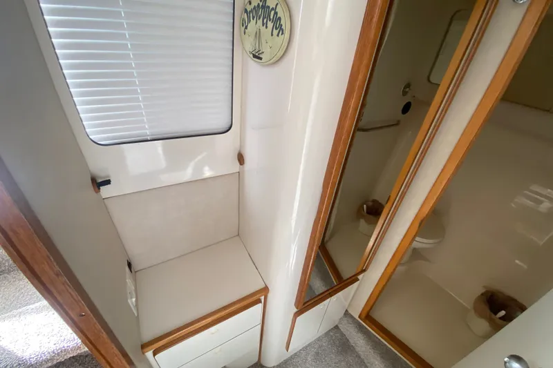 Slide: The Image of Interior of 1996 Sea Ray 440 Express Bridge, featuring compact bathroom and storage area. - 32