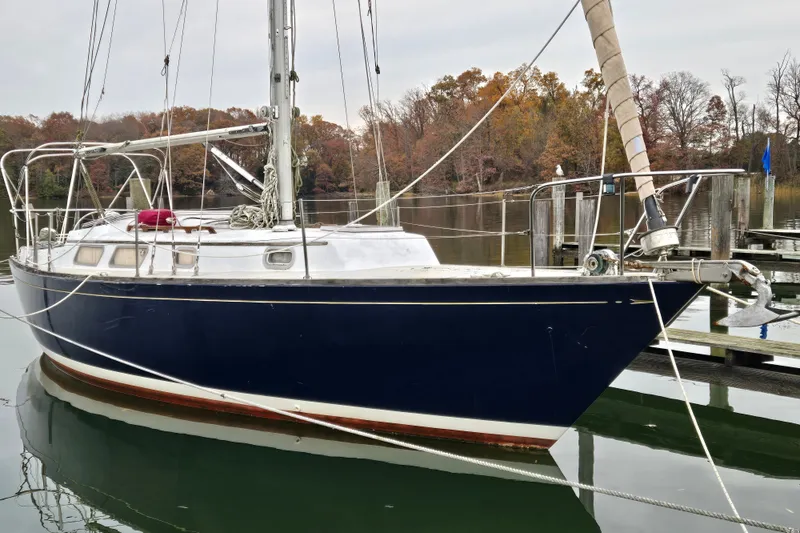 Slide: The Image of 1978 Bristol 35.5 sailboat docked on calm water with autumn trees in background. - 36