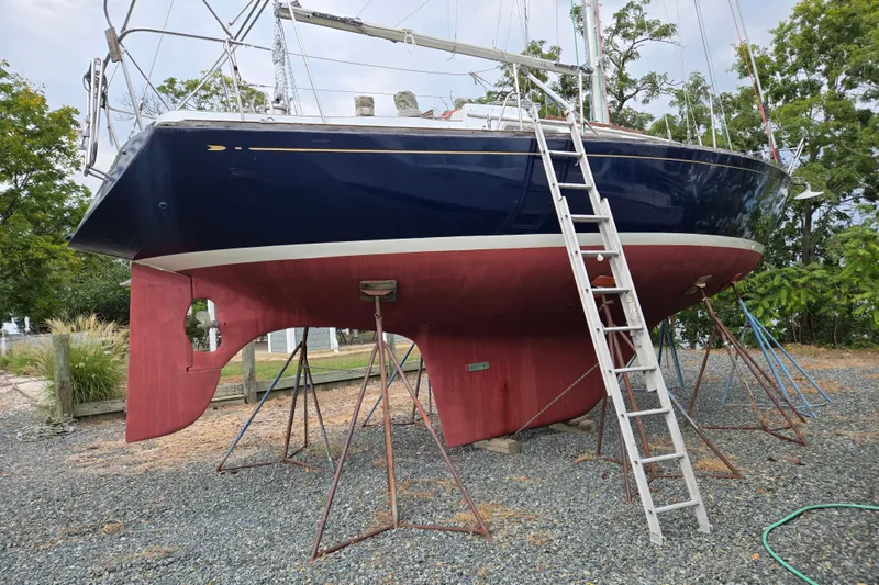 Slide: The Image of 1978 Bristol 35.5 sailboat on stands, with a ladder, in a boatyard setting. - 34