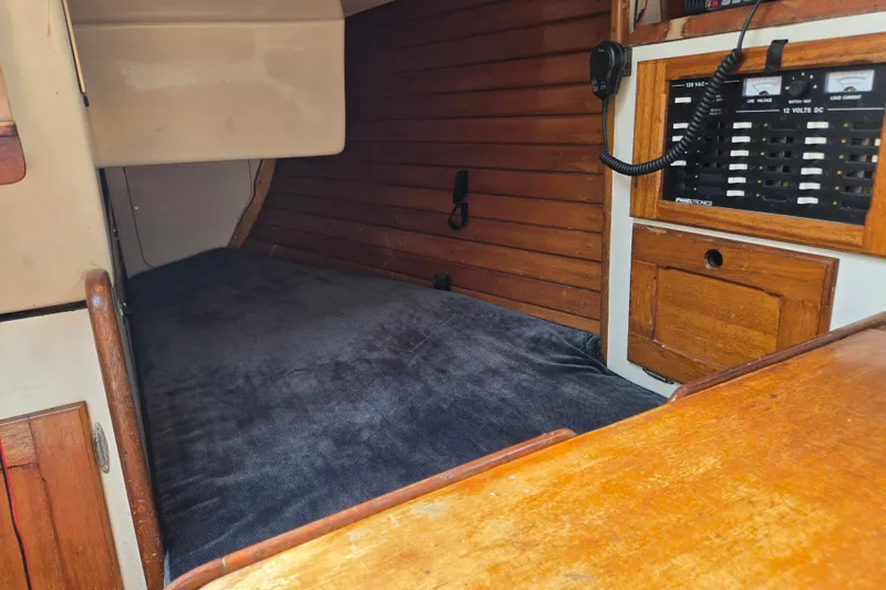 Slide: The Image of Interior cabin of a 1978 Bristol 35.5 sailboat with wooden paneling and control panel. - 13