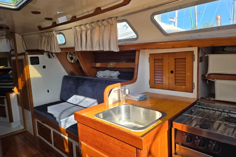 Slide: The Image of 1978 Bristol 35.5 yacht interior with wooden cabinetry, sink, and seating area. - 23