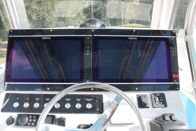 Slide: The Image of 2018 Lightning 38 Center Console dashboard with dual Simrad displays and control panel. - 9