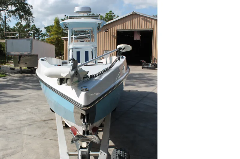 Slide: The Image of 2018 Lightning 38 Center Console boat on trailer outside a garage. - 3