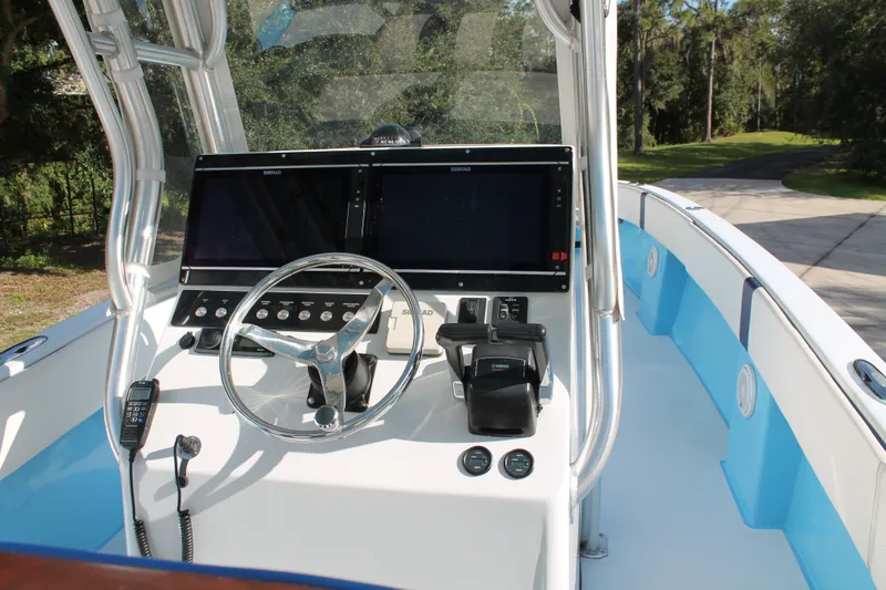 Slide: The Image of 2018 Lightning 38 Center Console boat helm with dual screens and steering wheel. - 8