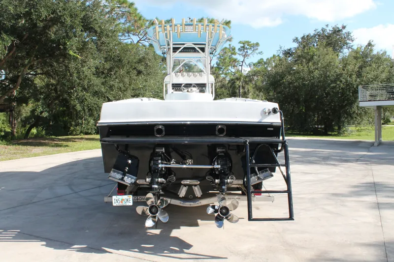 Slide: The Image of 2018 Lightning 38 Center Console boat, rear view with dual propellers, parked outdoors. - 2