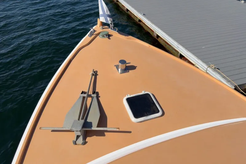 Slide: The Image of Bow of 1985 Holland 32 boat docked, featuring anchor and hatch. - 8