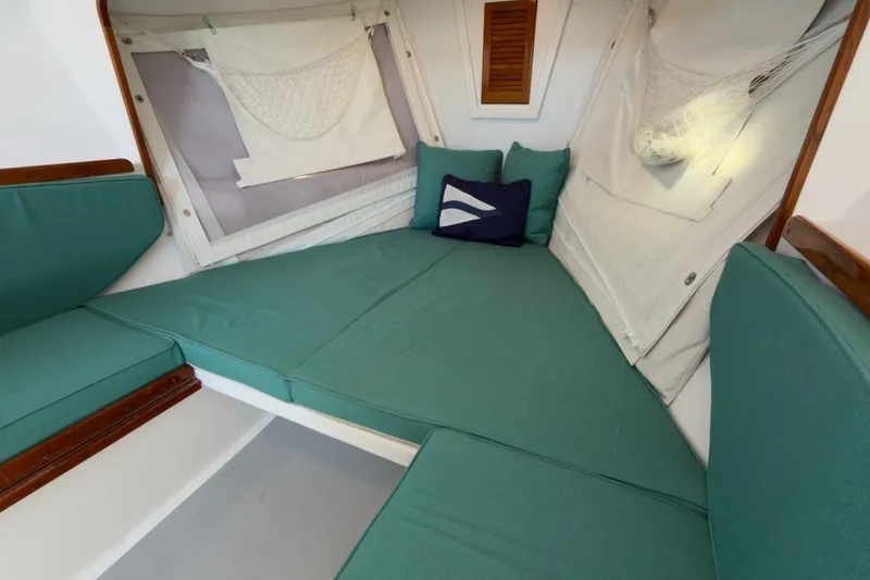 Slide: The Image of Cozy interior of 1985 Holland 32 sailboat with teal cushions and nautical decor. - 28
