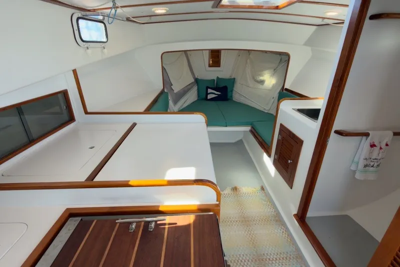 Slide: The Image of Interior of a 1985 Holland 32 sailboat with cozy seating and wooden accents. - 25