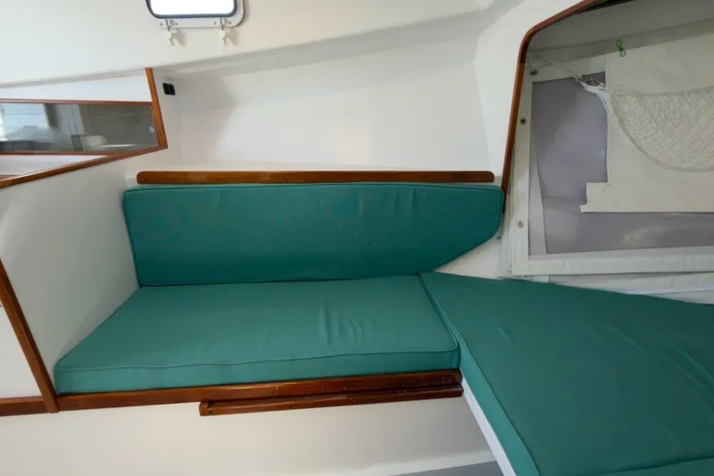 Slide: The Image of Interior of a 1985 Holland 32 sailboat with teal cushions and wooden trim. - 30
