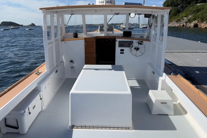 Slide: The Image of 1985 Holland 32 boat interior with helm, docked by scenic coastline. - 12