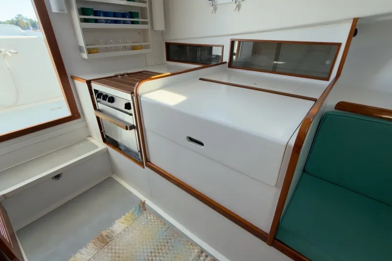 Slide: The Image of Interior of a 1985 Holland 32 boat featuring a compact kitchen area. - 34