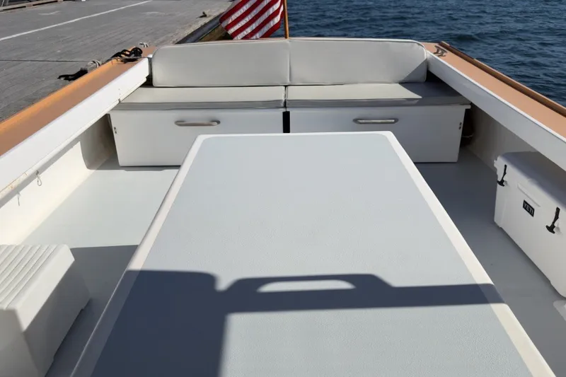 Slide: The Image of Interior of a 1985 Holland 32 boat with seating and storage, docked by the water. - 14