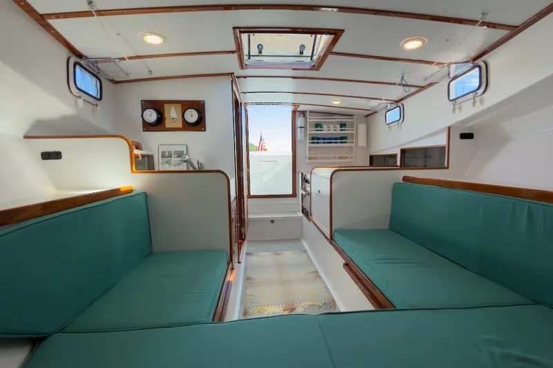 Slide: The Image of Interior of a 1985 Holland 32 boat with teal seating and wooden accents. - 31