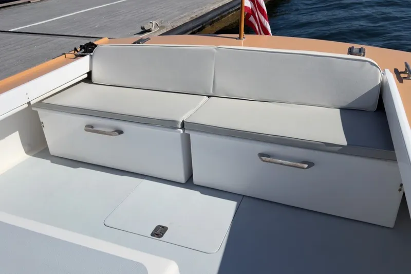 Slide: The Image of 1985 Holland 32 boat interior with cushioned seating and storage compartments. - 16