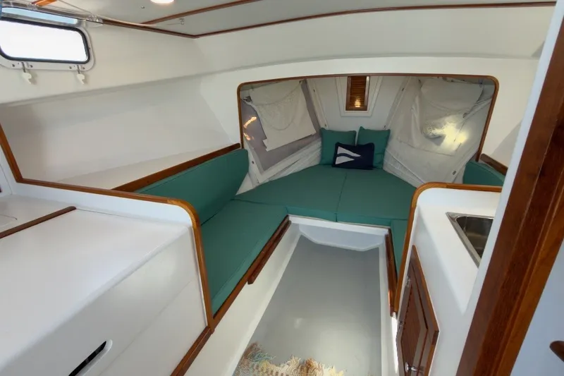 Slide: The Image of Cozy interior of 1985 Holland 32 sailboat with teal seating and wooden accents. - 27