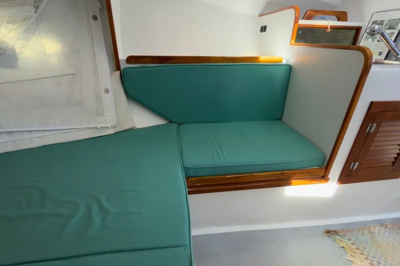 Slide: The Image of Interior of a 1985 Holland 32 boat with teal cushions and wooden accents. - 29