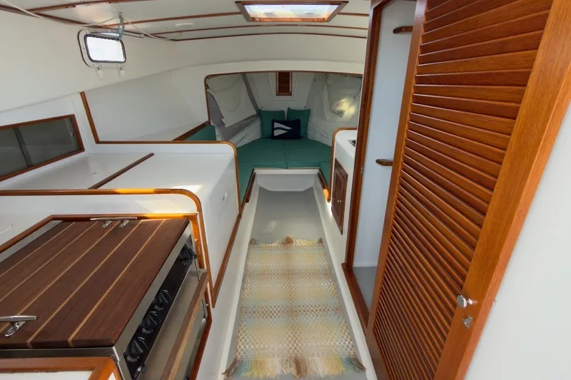 Slide: The Image of Interior of a 1985 Holland 32 yacht with wood accents and cozy seating area. - 24