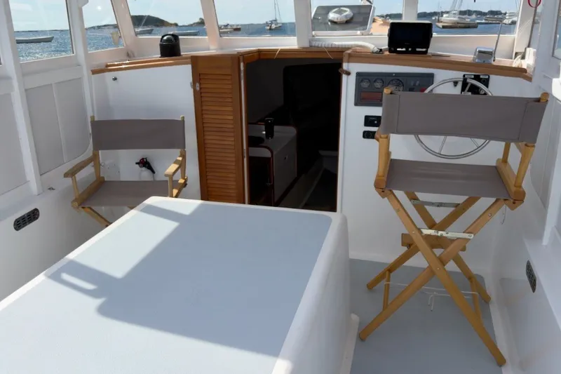 Slide: The Image of Interior of 1985 Holland 32 boat with chairs and helm, overlooking water. - 20