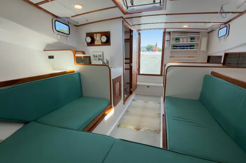 Slide: The Image of Interior of a 1985 Holland 32 boat with teal seating and wooden accents. - 32