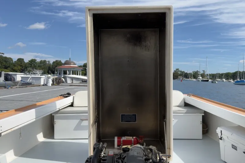 Slide: The Image of 1985 Holland 32 boat interior with engine compartment, docked at marina with sailboats. - 42