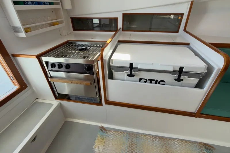 Slide: The Image of Compact kitchen area in a 1985 Holland 32 boat with stove and cooler. - 38