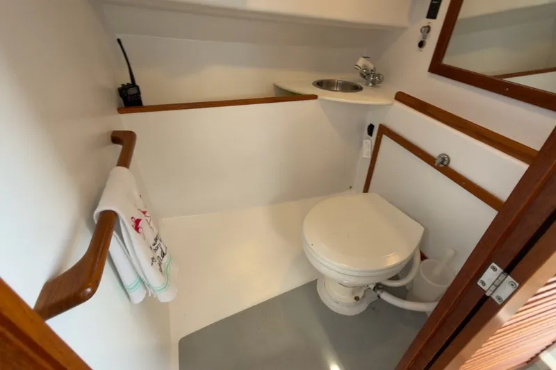 Slide: The Image of Compact bathroom in a 1985 Holland 32 boat, featuring a toilet and sink. - 35