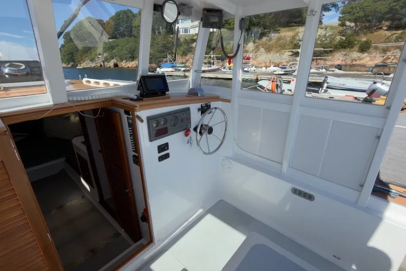 Slide: The Image of Interior view of a 1985 Holland 32 boat cockpit with steering wheel and control panel. - 21