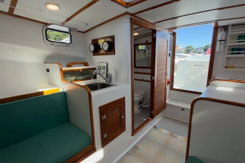 Slide: The Image of Interior of a 1985 Holland 32 boat with kitchenette and seating area. - 33