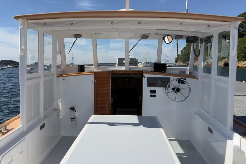 Slide: The Image of 1985 Holland 32 boat interior with steering wheel, dashboard, and open water view. - 18