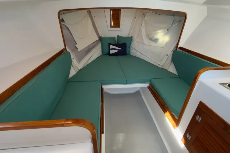 Slide: The Image of Cozy interior of 1985 Holland 32 sailboat with teal cushions and wooden accents. - 26