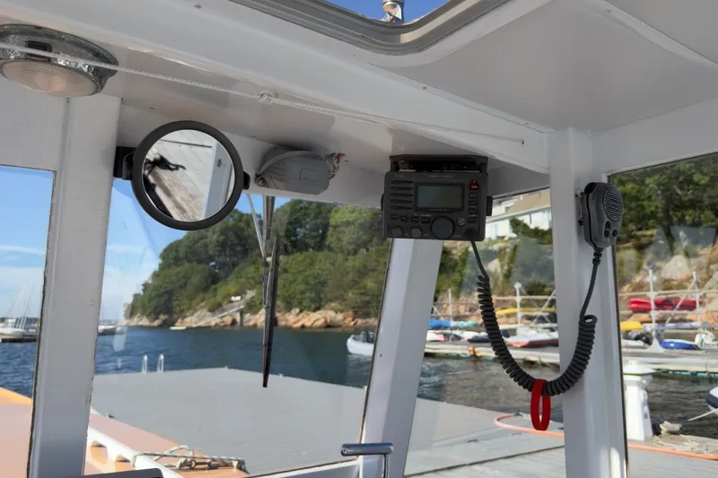 Slide: The Image of Interior view of a 1985 Holland 32 boat with radio equipment and scenic harbor background. - 23