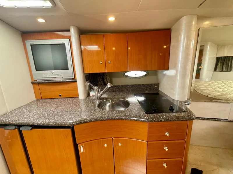 Slide: The Image of 2003 Formula 40 PC yacht kitchen with wood cabinets, sink, stove, and TV. - 16