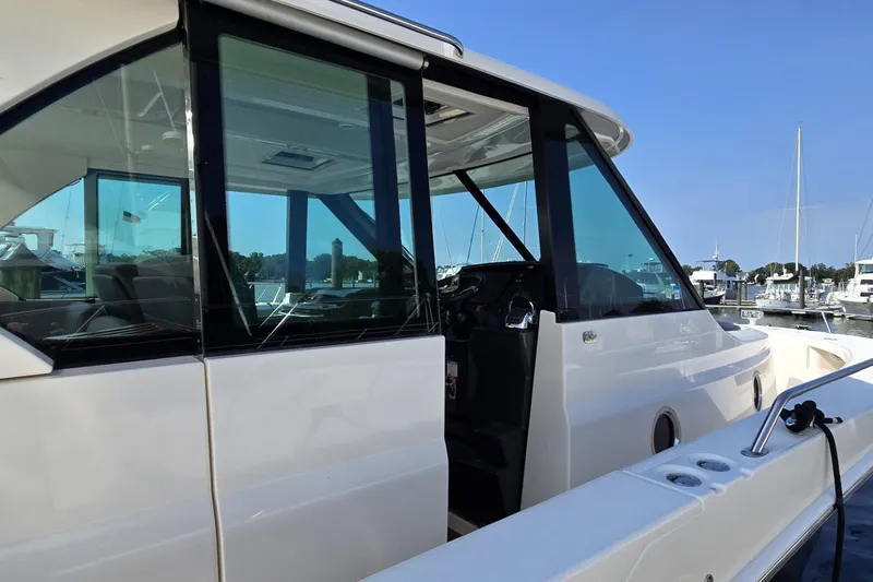 Slide: The Image of 2016 Tiara Yachts Q44 at marina, showcasing sleek design and spacious interior. - 29