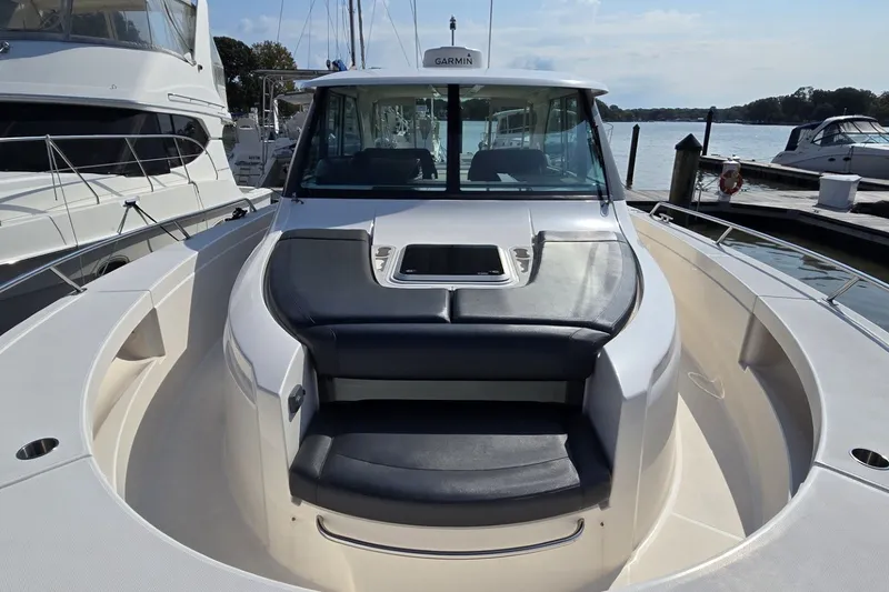 Slide: The Image of 2016 Tiara Yachts Q44 boat with sleek seating and modern design at a marina. - 33