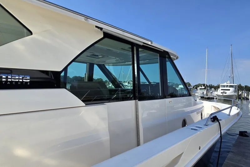 Slide: The Image of 2016 Tiara Yachts Q44 docked at marina, showcasing sleek design and modern windows. - 28
