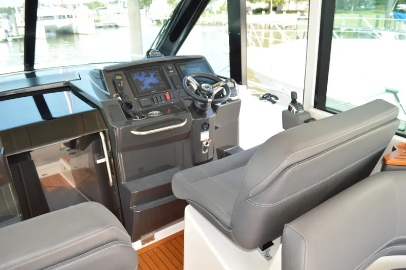 Slide: The Image of 2016 Tiara Yachts Q44 helm with modern navigation equipment and comfortable seating. - 51