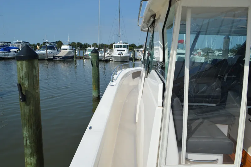 Slide: The Image of 2016 Tiara Yachts Q44 docked at marina, showcasing sleek design and spacious deck. - 30