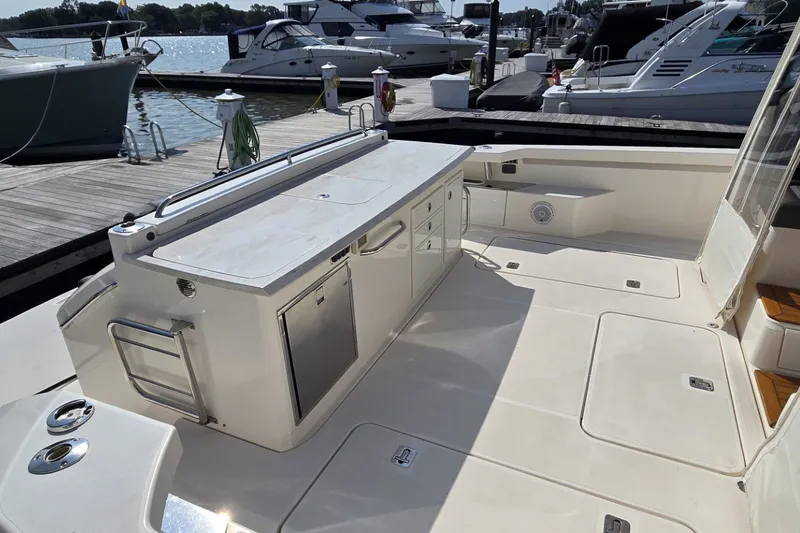 Slide: The Image of 2016 Tiara Yachts Q44 deck with storage and seating, docked at marina. - 20