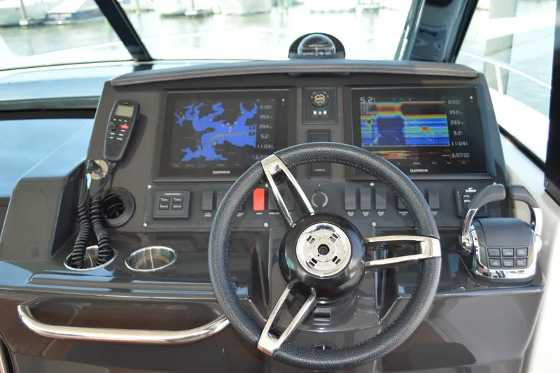 Slide: The Image of 2016 Tiara Yachts Q44 helm with Garmin navigation displays and steering wheel. - 53
