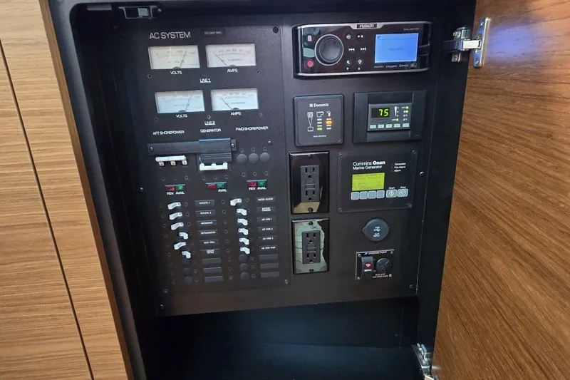 Slide: The Image of Electrical control panel inside 2016 Tiara Yachts Q44, featuring various switches and outlets. - 71