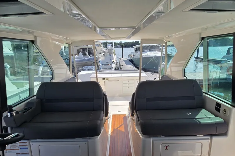 Slide: The Image of Interior view of 2016 Tiara Yachts Q44, featuring sleek seating and waterfront backdrop. - 49