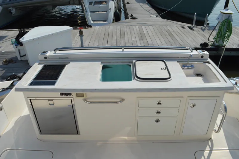 Slide: The Image of Outdoor kitchen on 2016 Tiara Yachts Q44, featuring sink, grill, and storage. - 22