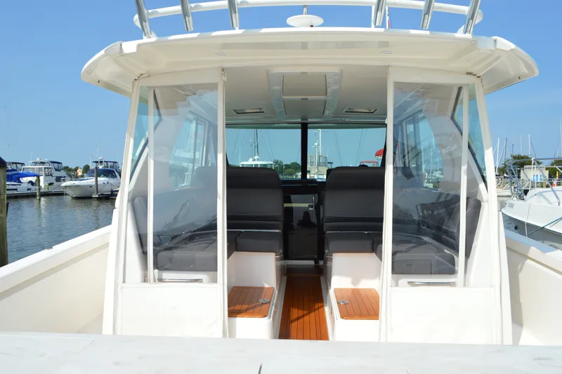 Slide: The Image of 2016 Tiara Yachts Q44 interior view at marina, showcasing seating and helm area. - 42