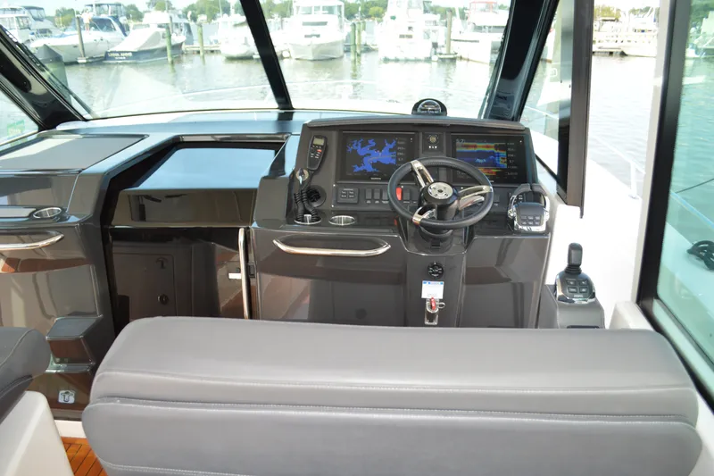 Slide: The Image of 2016 Tiara Yachts Q44 helm with navigation screens and steering wheel. - 52