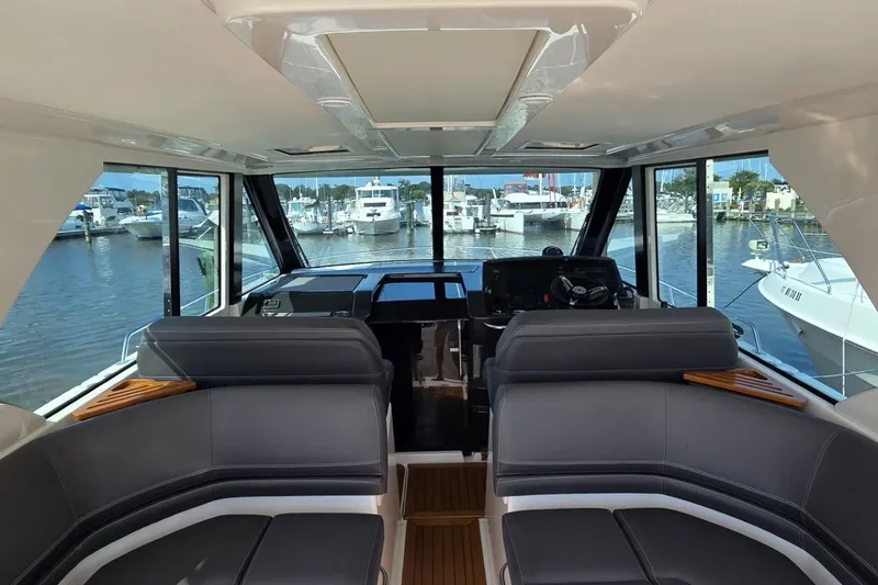 Slide: The Image of Interior view of 2016 Tiara Yachts Q44, featuring sleek seating and panoramic windows. - 47